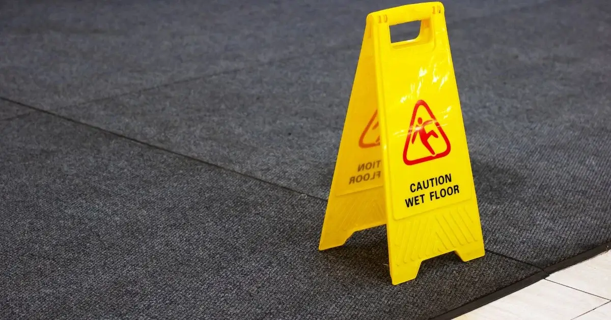 Caution wet floor sign on commercial floor mat